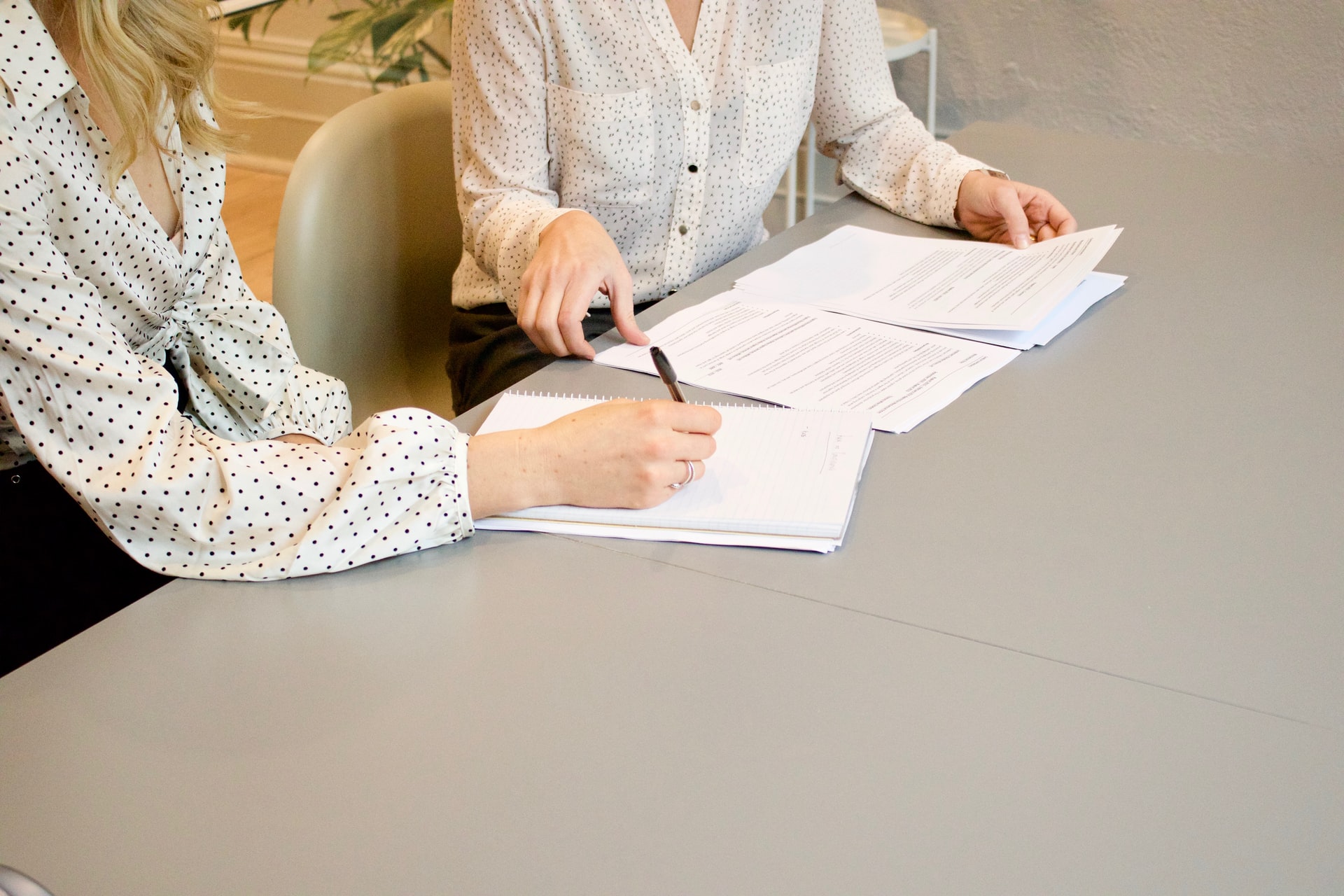 two people reading and signing a contract