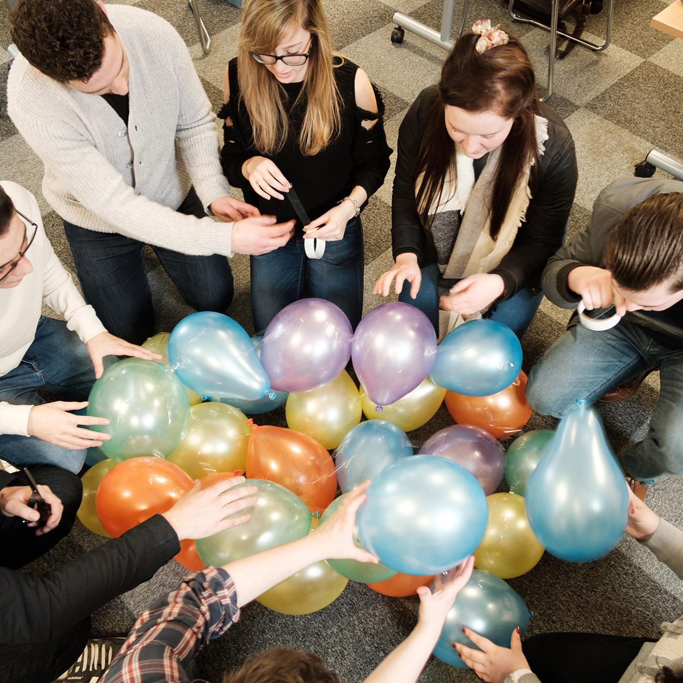 A group of students assemble balloons as part of a classroom task